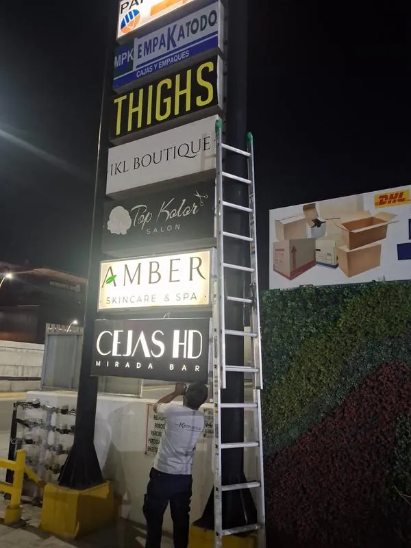 Instalación nocturna de lonas back-light en directorio de plaza comercial en Monterrey